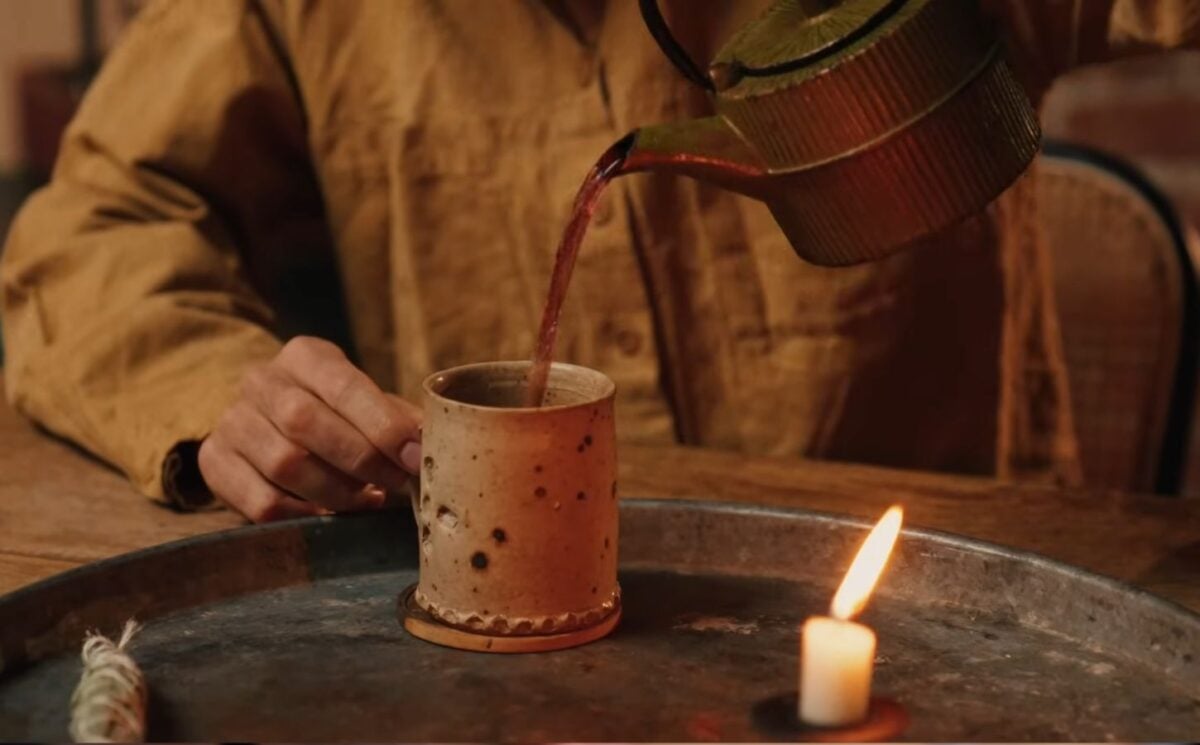 Former chef Gaz Oakley pours tea into a clay mug while shooting his video about Herbal teas for energy, immunity, sleep, and love