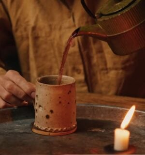 Former chef Gaz Oakley pours tea into a clay mug while shooting his video about Herbal teas for energy, immunity, sleep, and love