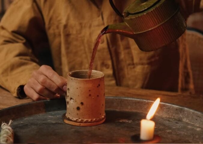 Former chef Gaz Oakley pours tea into a clay mug while shooting his video about Herbal teas for energy, immunity, sleep, and love