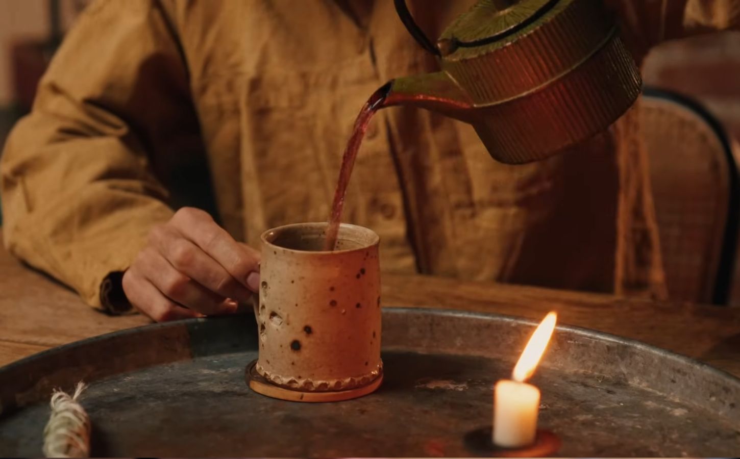 Former chef Gaz Oakley pours tea into a clay mug while shooting his video about Herbal teas for energy, immunity, sleep, and love