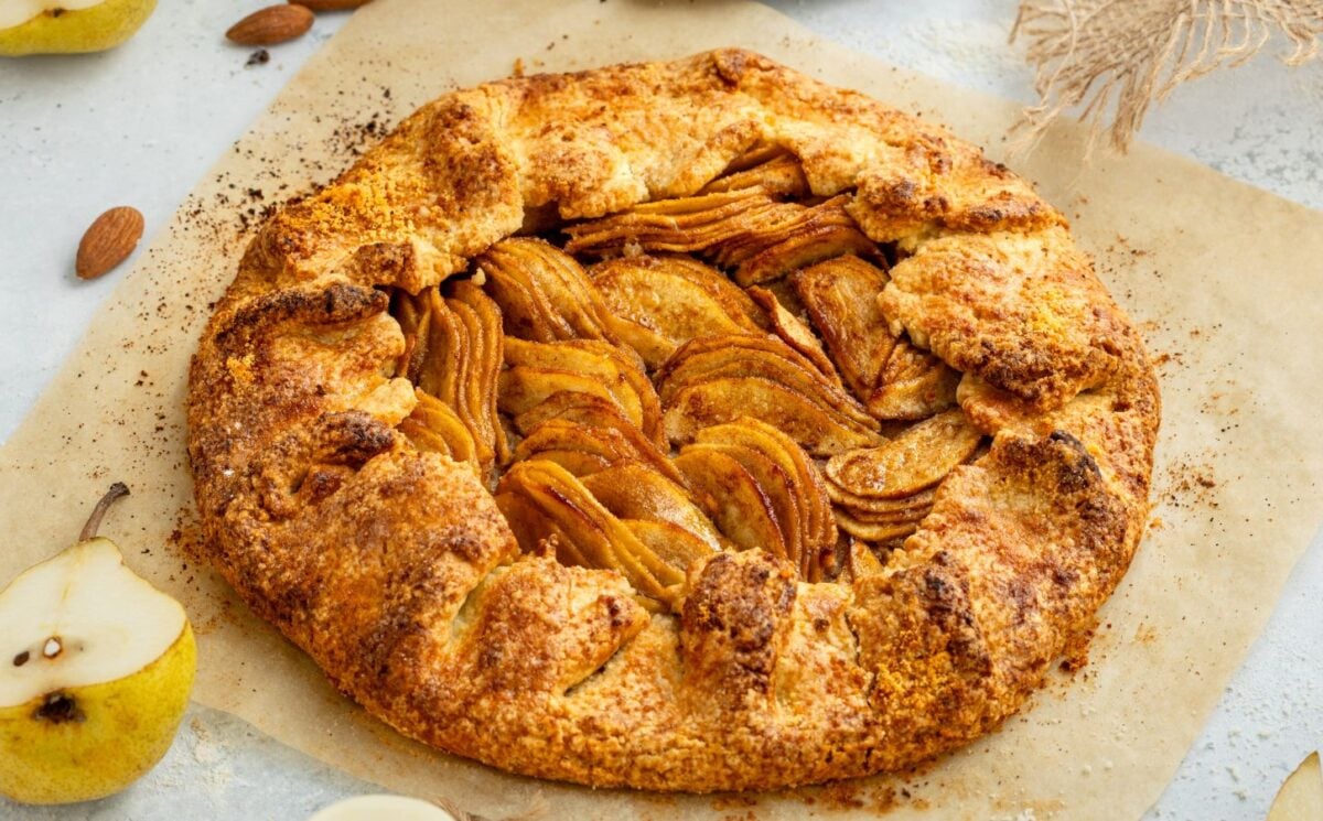 an image of an almond pear galette with slices of almond and pear surrounding the tart for recipes that use September produce