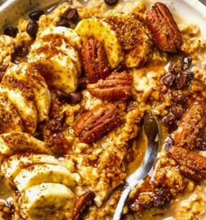 a bowl of banana, walnut and chocolate porridge with nutty drizzle and vegan protein powder