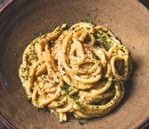 vegan Cacio e Pepe pasta with bucatini, nutritional yeast, cashews, lemon, and pepper