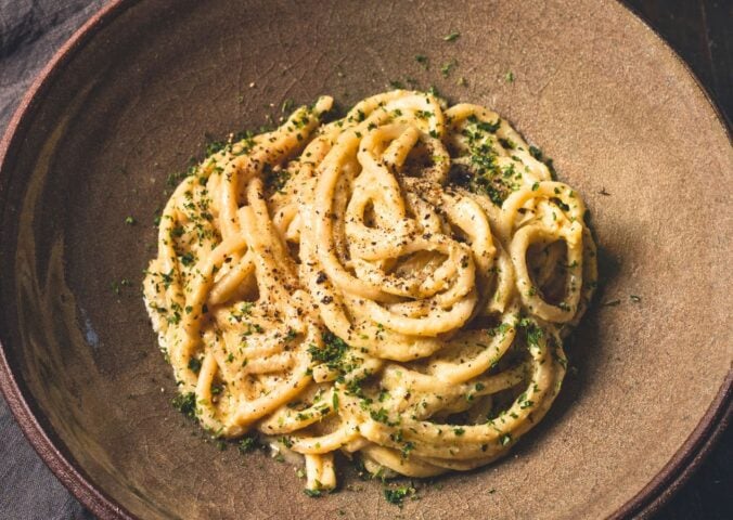 vegan Cacio e Pepe pasta with bucatini, nutritional yeast, cashews, lemon, and pepper
