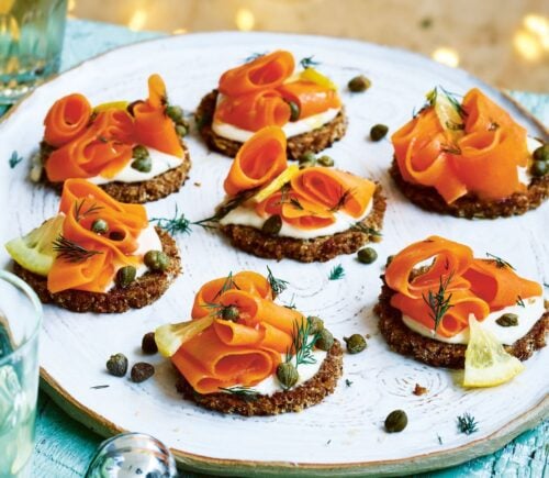 carrot lox with cream cheese canapés on little pieces of bread on a plate