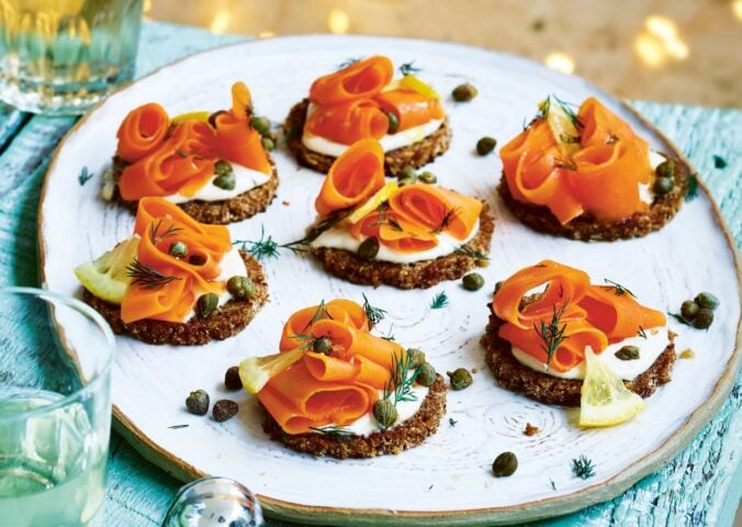 carrot lox with cream cheese canapés on little pieces of bread on a plate