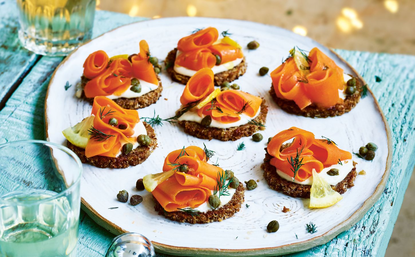 carrot lox with cream cheese canapés on little pieces of bread on a plate