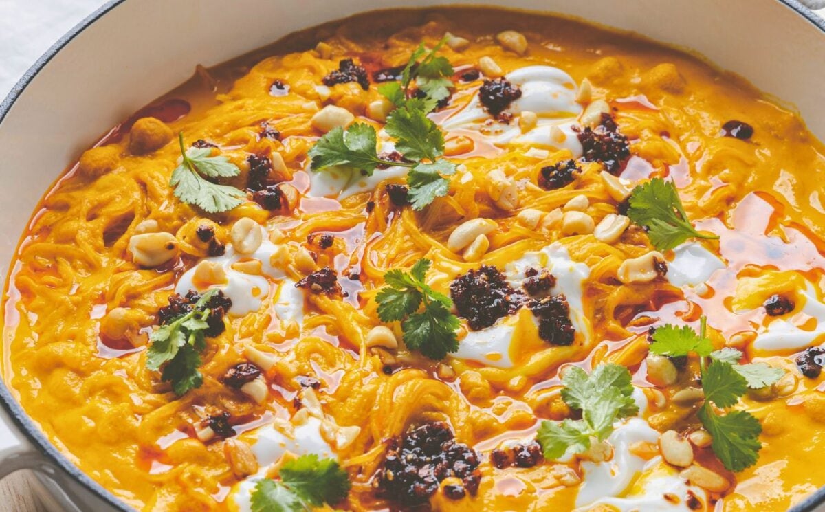 a pot of carrot noodle soup with Thai curry, peanuts, chili, chickpeas, and coriander for recipes that use September produce