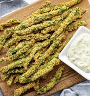 A wooden chopping board covered in oil-free green bean fries for green bean recipes