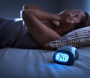 a woman struggling with insomnia relating to the link between diet and sleep