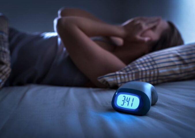 a woman struggling with insomnia relating to the link between diet and sleep