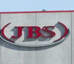 Photo shows the JBS logo in red on the front of a large grey building. JBS is launching a new plant-based collective