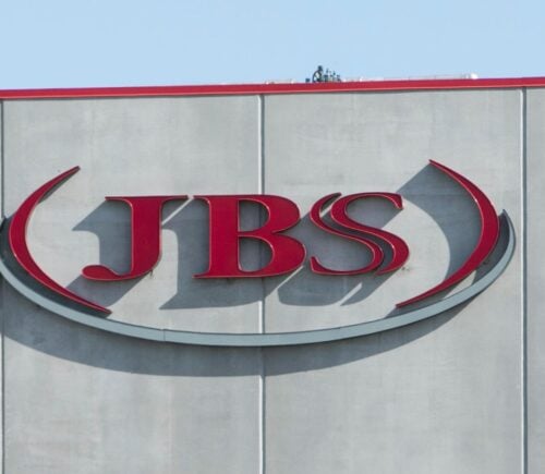 Photo shows the JBS logo in red on the front of a large grey building. JBS is launching a new plant-based collective