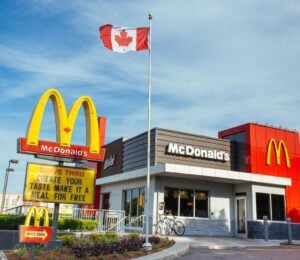 Photo shows a McDonald's restaurant in Canada with a Canadian flag flying above it