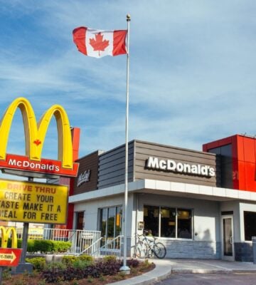 Photo shows a McDonald's restaurant in Canada with a Canadian flag flying above it