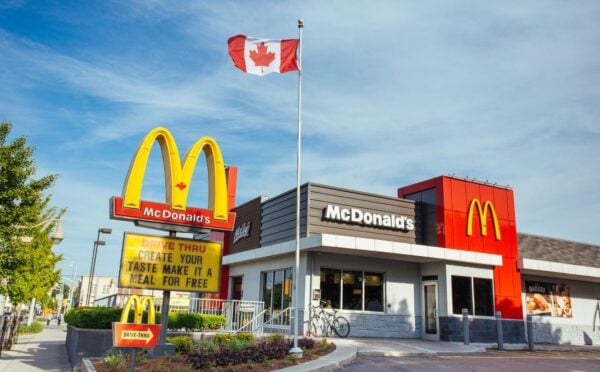 Photo shows a McDonald's restaurant in Canada with a Canadian flag flying above it