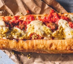 a vegan meatball parmigiana hero with cashew mozzarella, lentil meatballs, and basil
