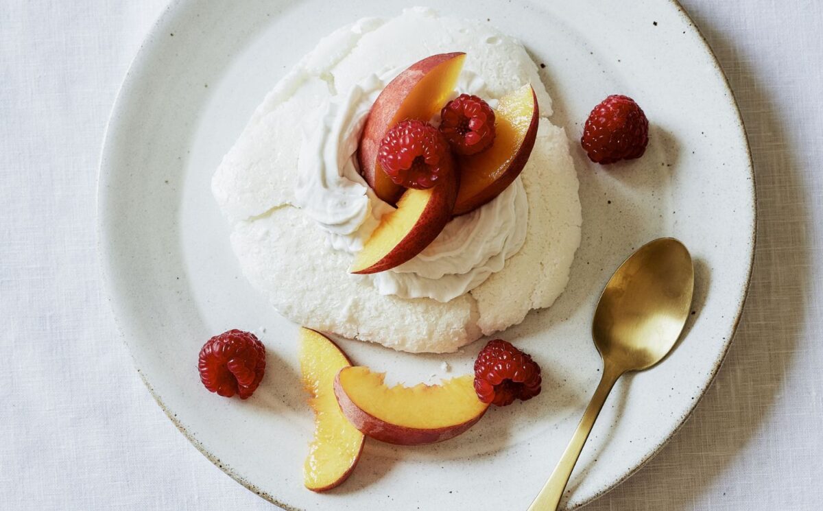 a plate of miracle meringues with coconut whipped cream and fruit