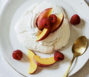 a plate of miracle meringues with coconut whipped cream and fruit