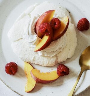a plate of miracle meringues with coconut whipped cream and fruit
