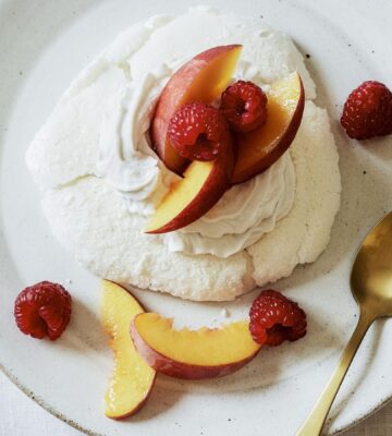 a plate of miracle meringues with coconut whipped cream and fruit