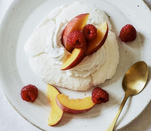 a plate of miracle meringues with coconut whipped cream and fruit