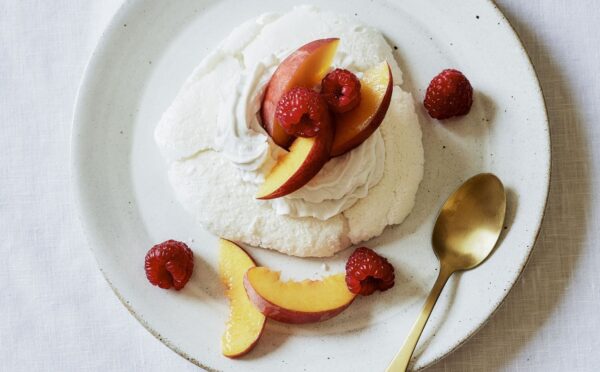 a plate of miracle meringues with coconut whipped cream and fruit