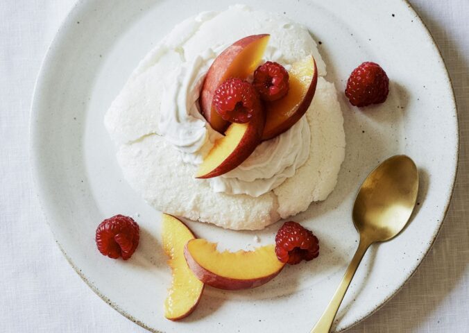 a plate of miracle meringues with coconut whipped cream and fruit