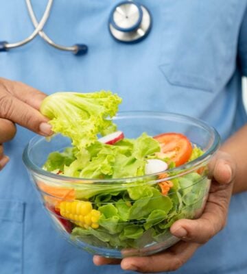 Plant-based diets are thought to cut disease risk, and the photo shows a Dr wearing scrubs and a stethoscope holding a glass bowl of salad