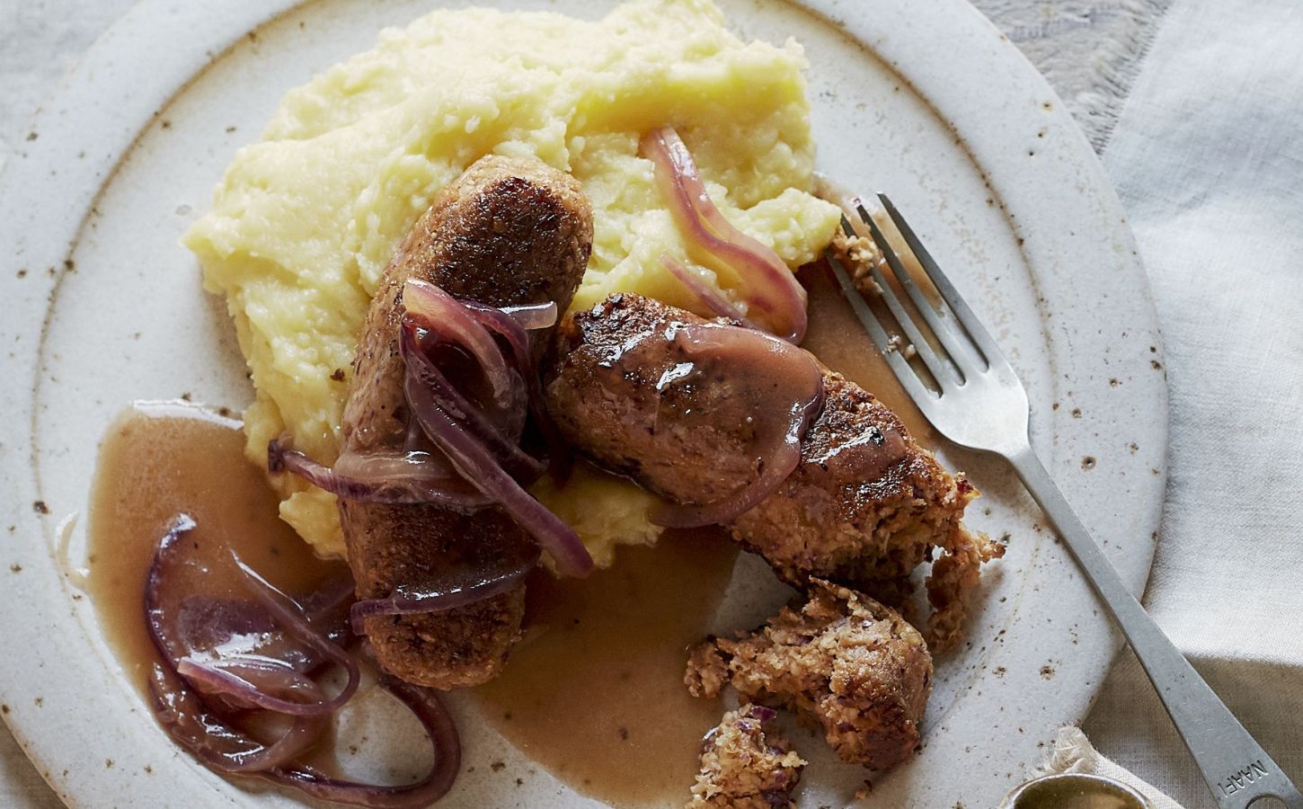 vegan sausage and mash made of walnuts, bread, and onions, served with creamy mash