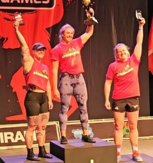 Photo shows vegan athlete Angeline Berva on the finishers' podium at the the European Strongman Games alongside her competitors