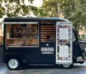 Photo shows a small doughnut van - here's how to start a vegan food truck