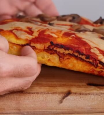 Freshly baked vegan pizza made with sweet potato pizza dough, topped with cashew cheese and mushrooms