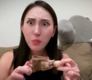 Perfect Carnivore influencer Steak and Butter Gal eating meat off a bone, promoting her meat-only diet