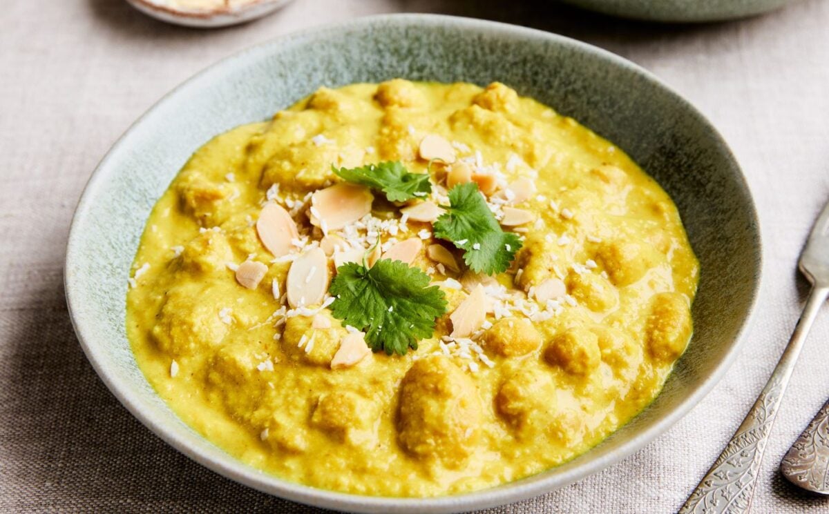 chickpeas and cannellini beans cooked in a coconut milk, carrot, and almond sauce for high-protein vegan recipes