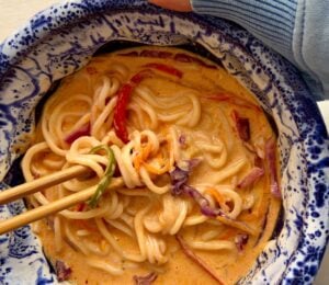 one-pan ramen with bell pepper, carrot, ginger, garlic, and red cabbage in a coconut milk broth