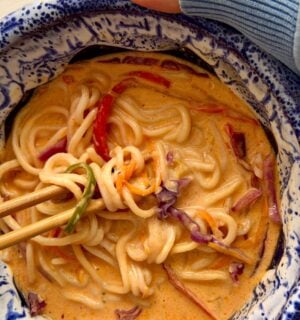 one-pan ramen with bell pepper, carrot, ginger, garlic, and red cabbage in a coconut milk broth