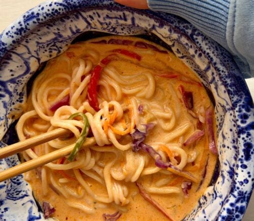 one-pan ramen with bell pepper, carrot, ginger, garlic, and red cabbage in a coconut milk broth