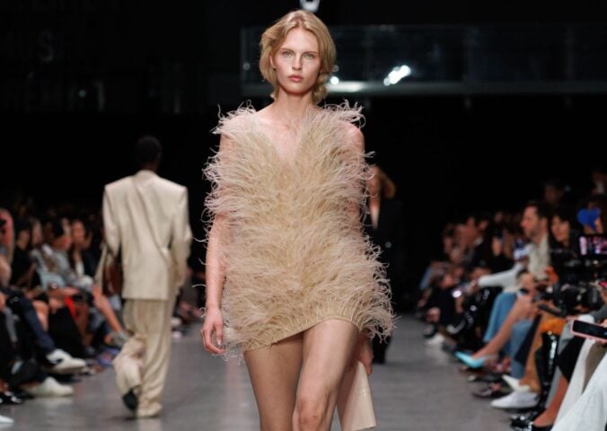 Photo shows a model at Paris Fashion Week wearing a Stella McCartney dress featuring vegan feathers from London-based company FEVVERS