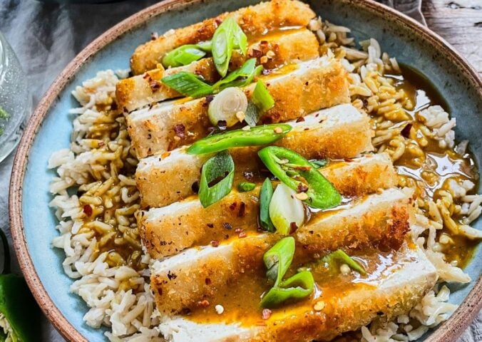 tofu katsu curry with brown rice, carrot and onion curry, and a panko-covered piece of tofu