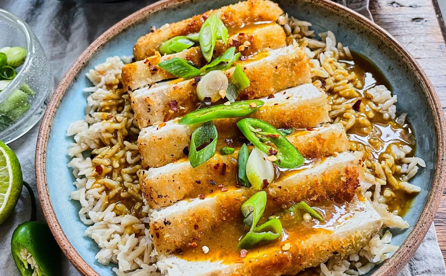 tofu katsu curry with brown rice, carrot and onion curry, and a panko-covered piece of tofu