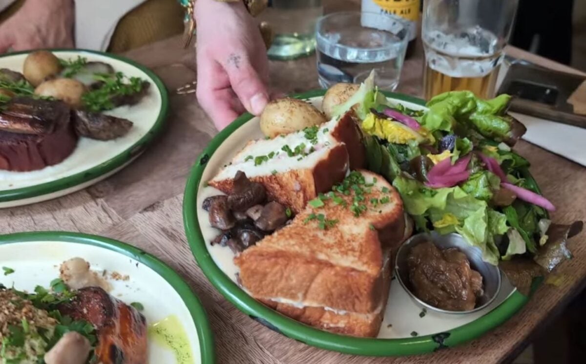 A waitress serves the main course for Daynesh and his family as he searches for the best vegan food in Paris