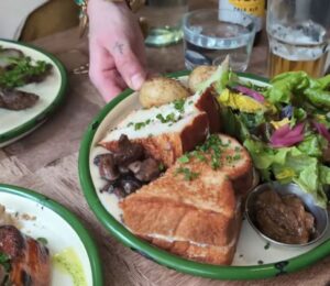 A waitress serves the main course for Daynesh and his family as he searches for the best vegan food in Paris