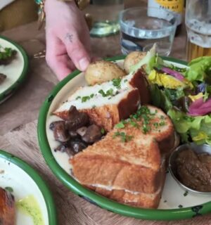 A waitress serves the main course for Daynesh and his family as he searches for the best vegan food in Paris