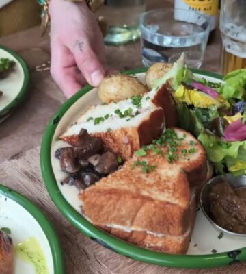 A waitress serves the main course for Daynesh and his family as he searches for the best vegan food in Paris