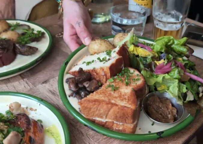 A waitress serves the main course for Daynesh and his family as he searches for the best vegan food in Paris