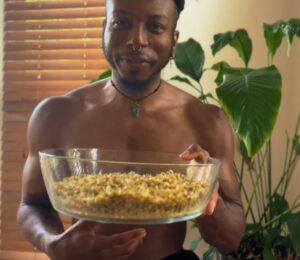 Shai Rowe holds a glass bowl with sprouted lentils, displaying the results of sprouting lentils at home