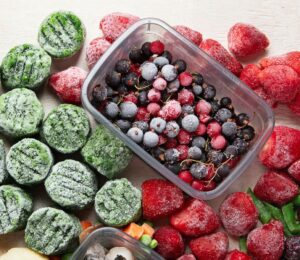 frozen fruits, berries, spinach and other vegetables in a picture together for why frozen produce might be healthier than fresh