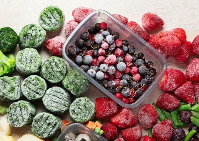 frozen fruits, berries, spinach and other vegetables in a picture together for why frozen produce might be healthier than fresh