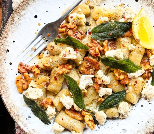 a plate of homemade gnocchi with sage, walnuts, and vegan blue cheese